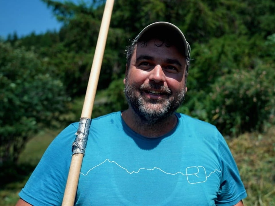 Ein Mann mit blauen Tshirt auf einer Wiese.