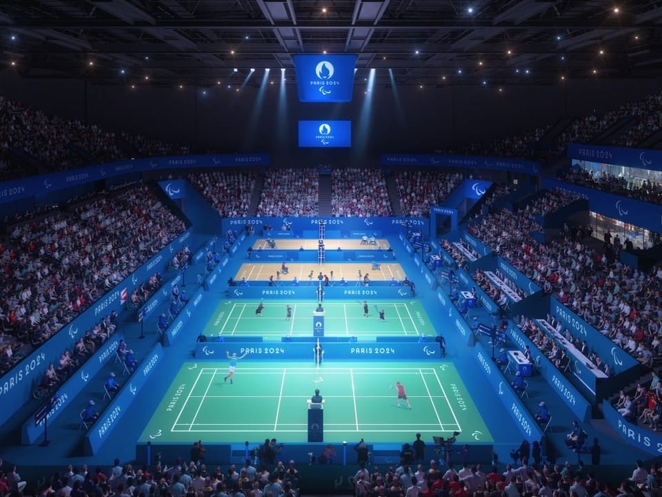 Grosses Indoor-Stadion mit Tennisplätzen und Publikum.