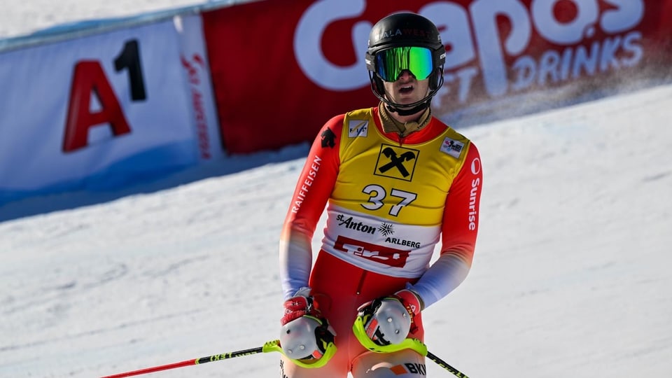 Skifahrer im roten Anzug auf der Piste.