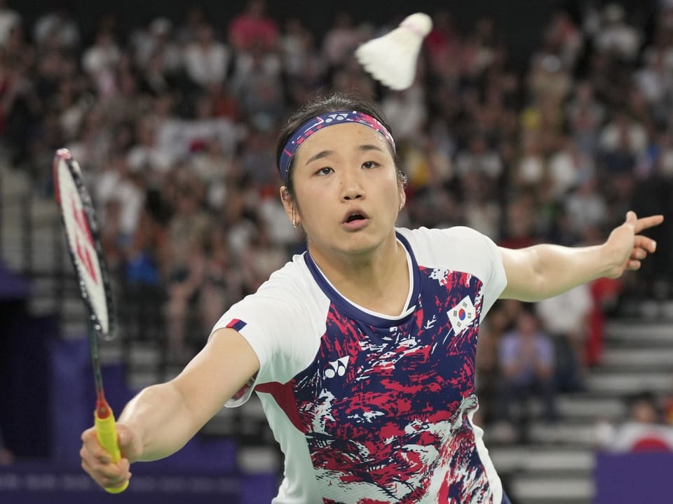 Badmintonspielerin schlägt vor der Menschenmenge.