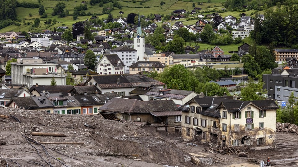 Dorf nach einem Erdrutsch mit beschädigten Gebäuden.