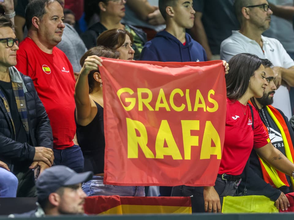 Menschenmenge mit einem Banner 'GRACIAS RAFA'.