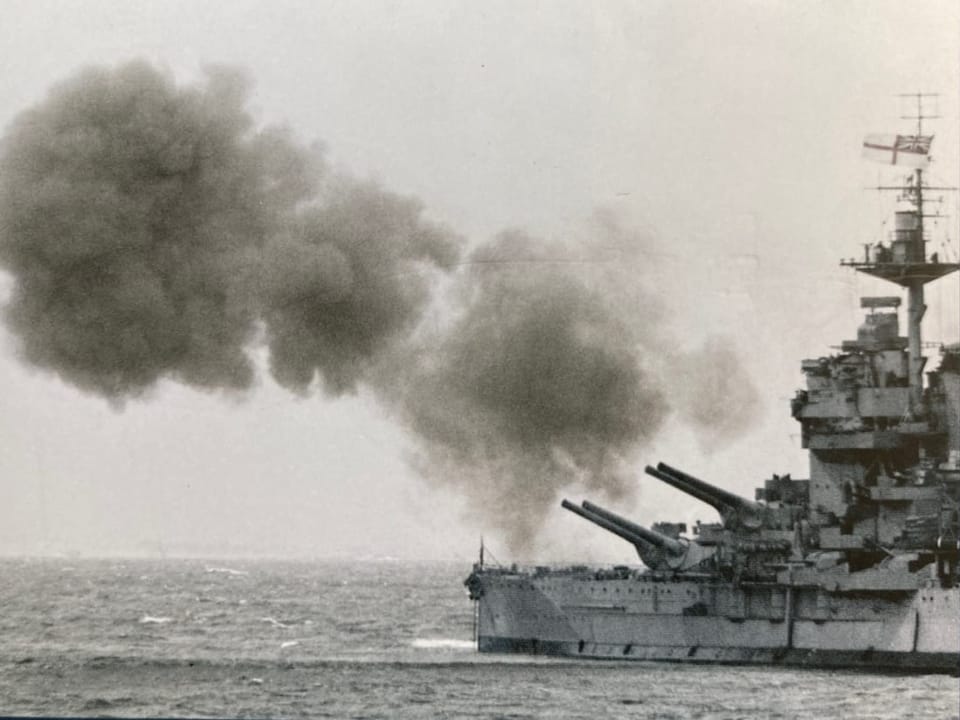 Schlachtschiff feuert Geschütze auf dem Meer.