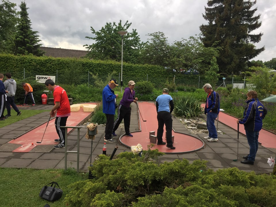 Zahlreiche Spieler sind auf den verschiedenen Bahnen der Minigolfanlage