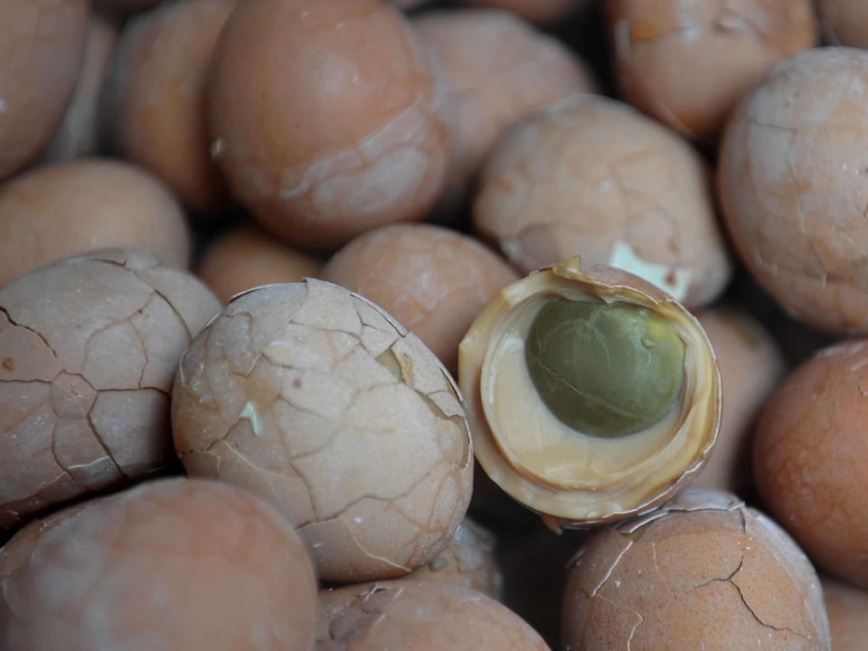 Ein geöffnetes Urinei mit grünlichem Dotter auf weiteren Urineiern liegend.