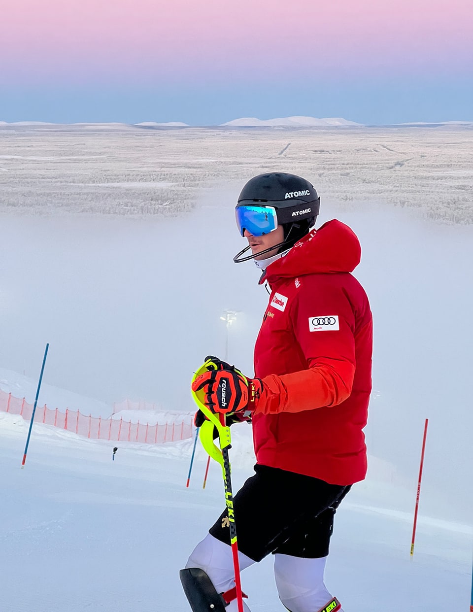 Skifahrer in roter Jacke auf verschneiter Skipiste.