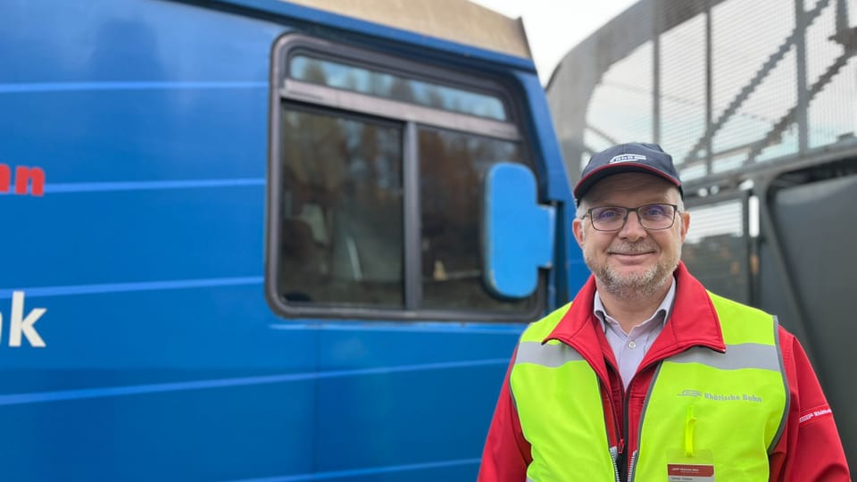 Simon Rohner steht vor blauem Zug.