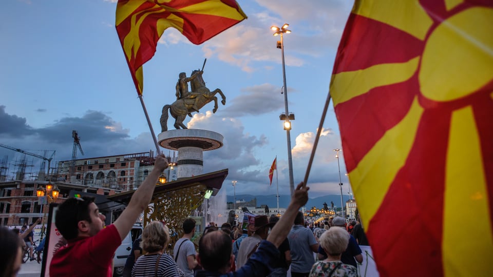 Demonstrierende auf dem Hauptplatz mit der Alexanderstatue in Skopje