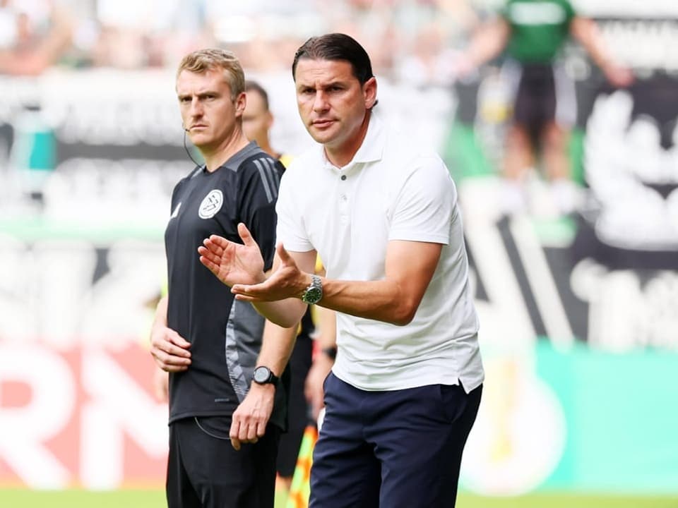 Zwei Fussballtrainer am Spielfeldrand.