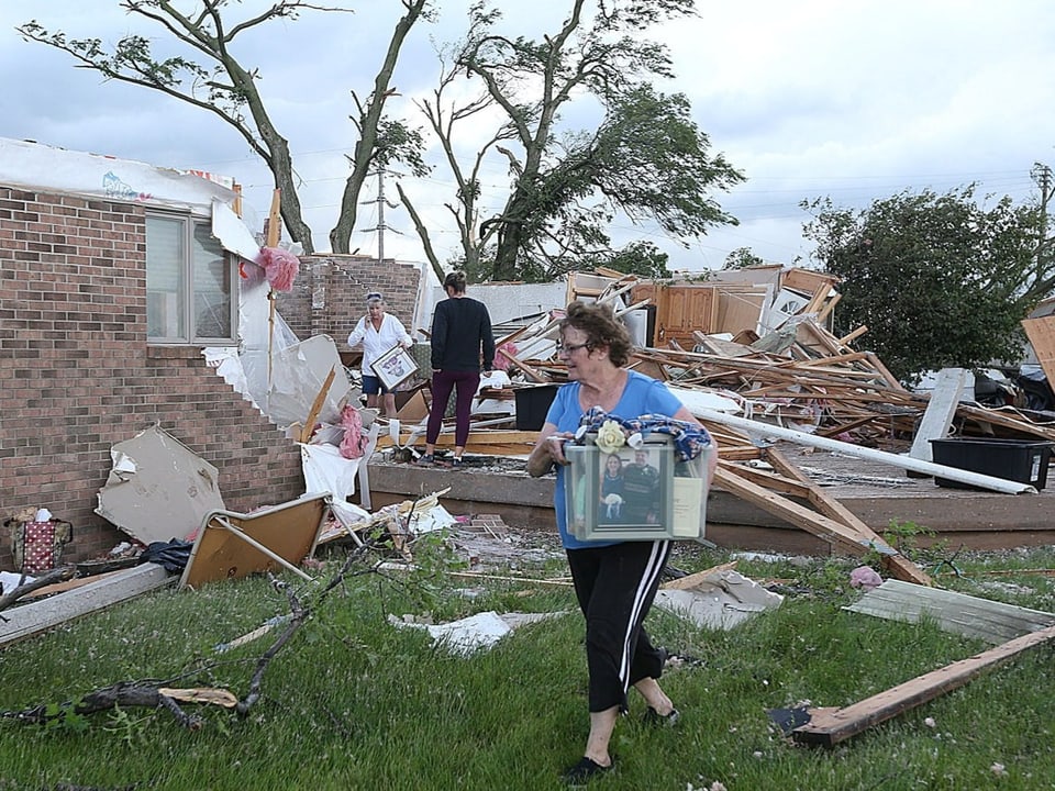 Menschen, die nach einem Tornado Trümmer aufräumen.