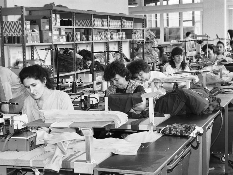 Frauen arbeiten an Nähmaschinen in einer Textilfabrik.