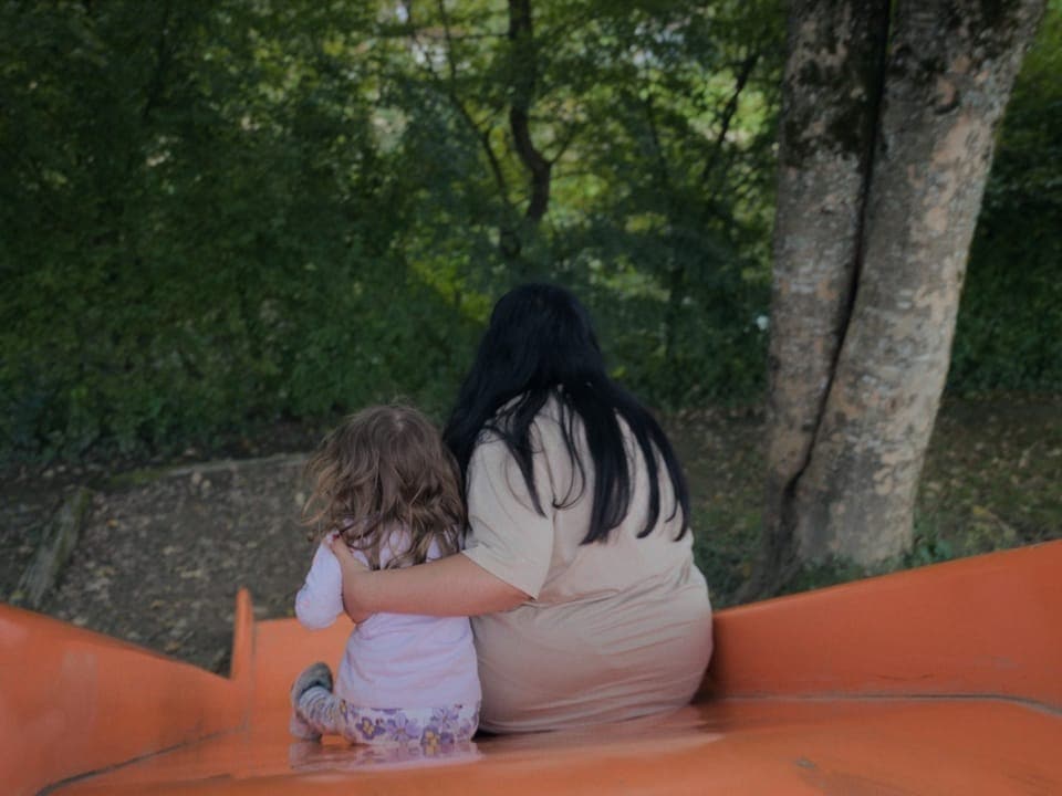 Nadja und ihre Tochter Elina auf der Rutschbahn auf dem Spielplatz