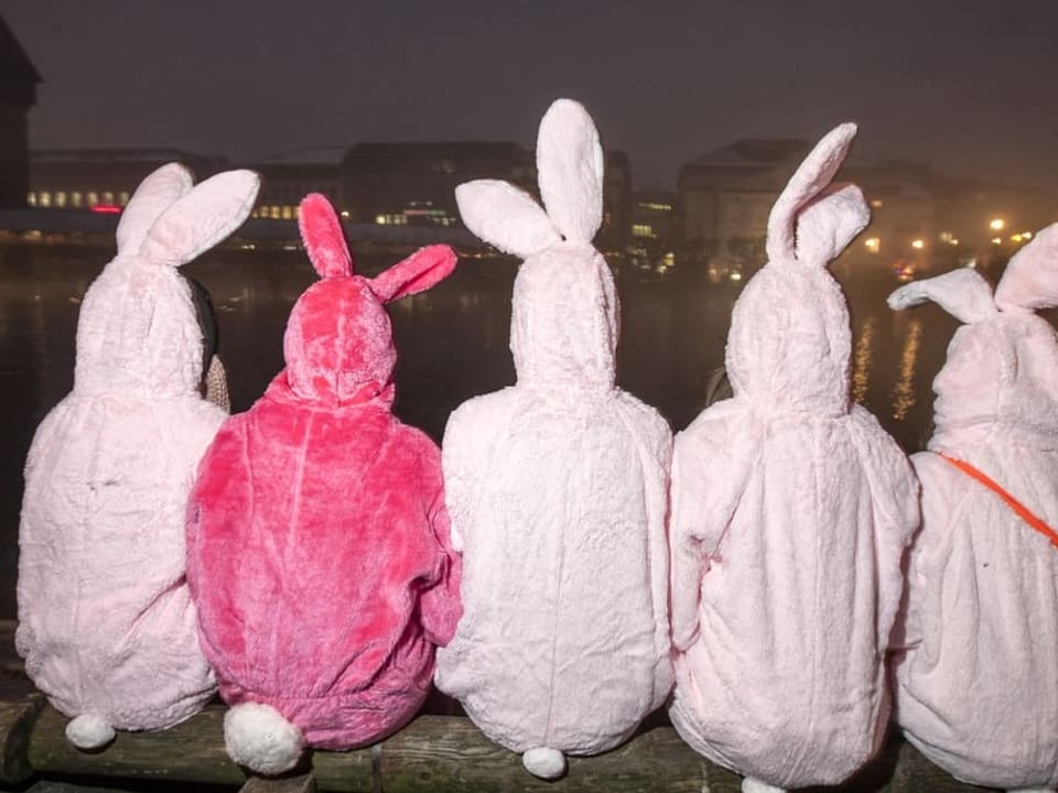 Jugendliche in Hasenkostümen sitzen an der Reuss in Luzern in der  Nacht