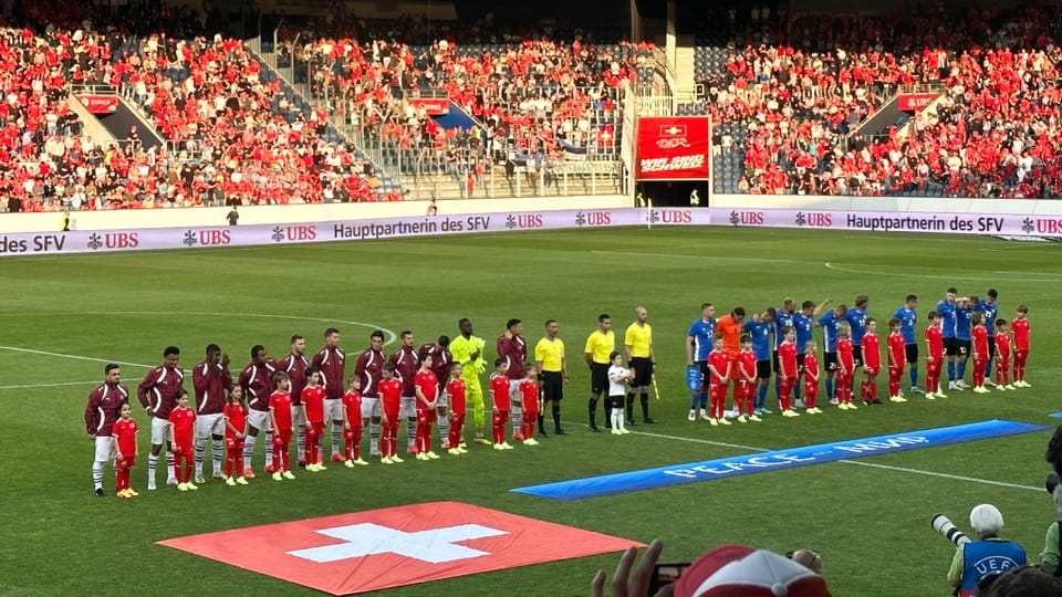 Spieler auf Feld mit Schweizer Flagge