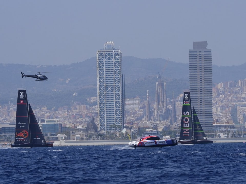 Alinghi-Segelboot liegt hinter Ineos zurück, die Skyline von Barcelona im Hintergrund zu sehen