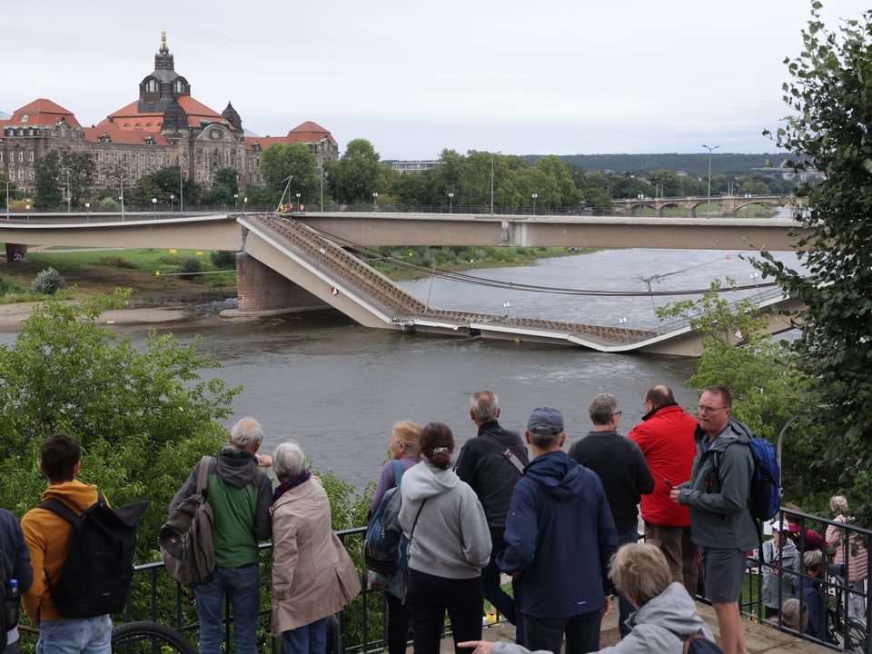 Leute betrachten die Brücke.