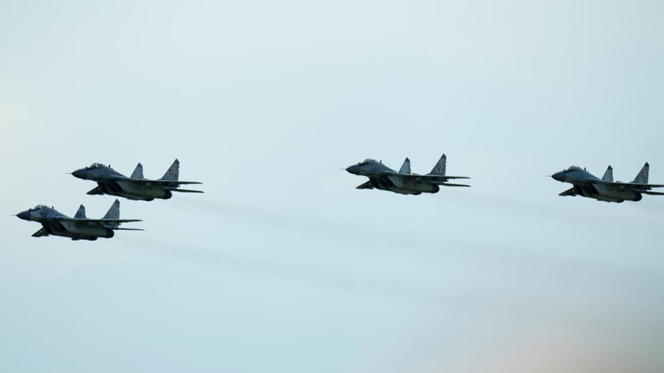Vier Kampfjets fliegen in Formation nebeneinander