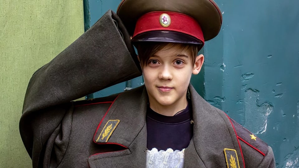 Ein Kind posiert in einer Militäruniform