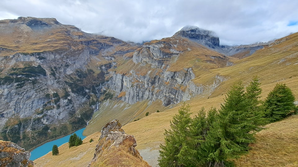 Berglandschaft mit Stausee und Wolken.