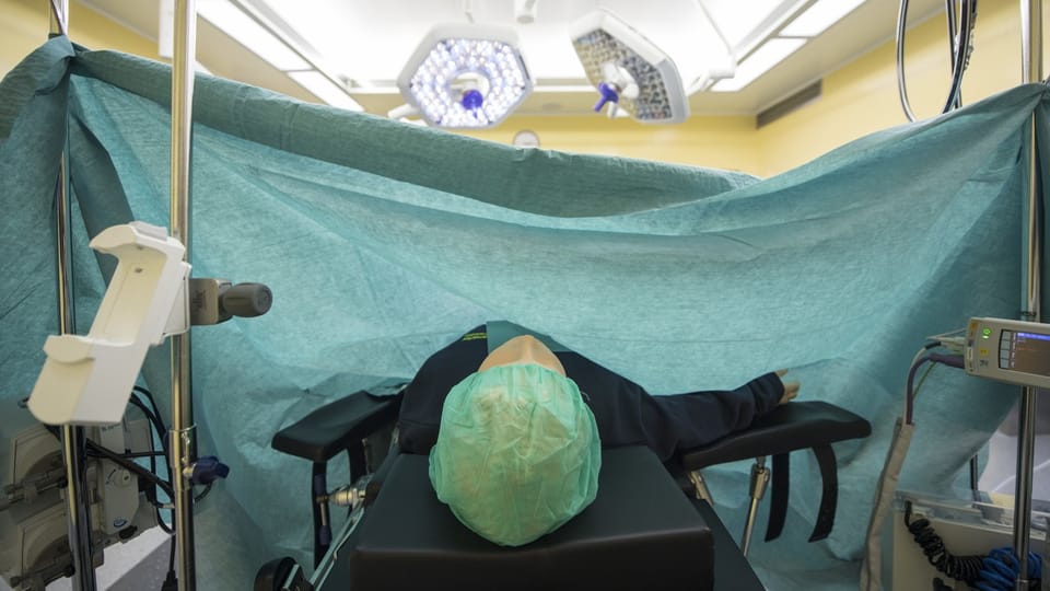 Patient auf einem OP-Tisch in einem Operationssaal.