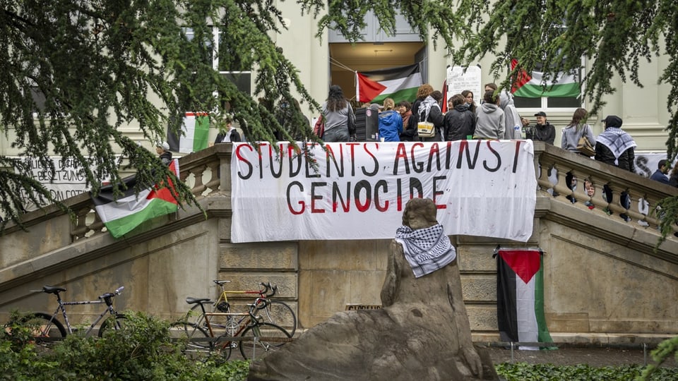 Studentendemonstration gegen Völkermord auf Treppe vor Gebäude.