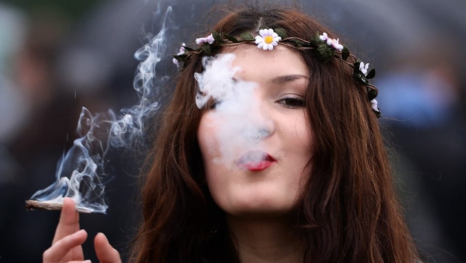 Eine Frau bläst Cannabis-Rauch aus