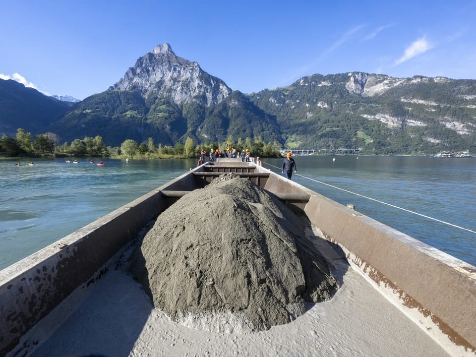 Beladenes Boot im See vor Berglandschaft.