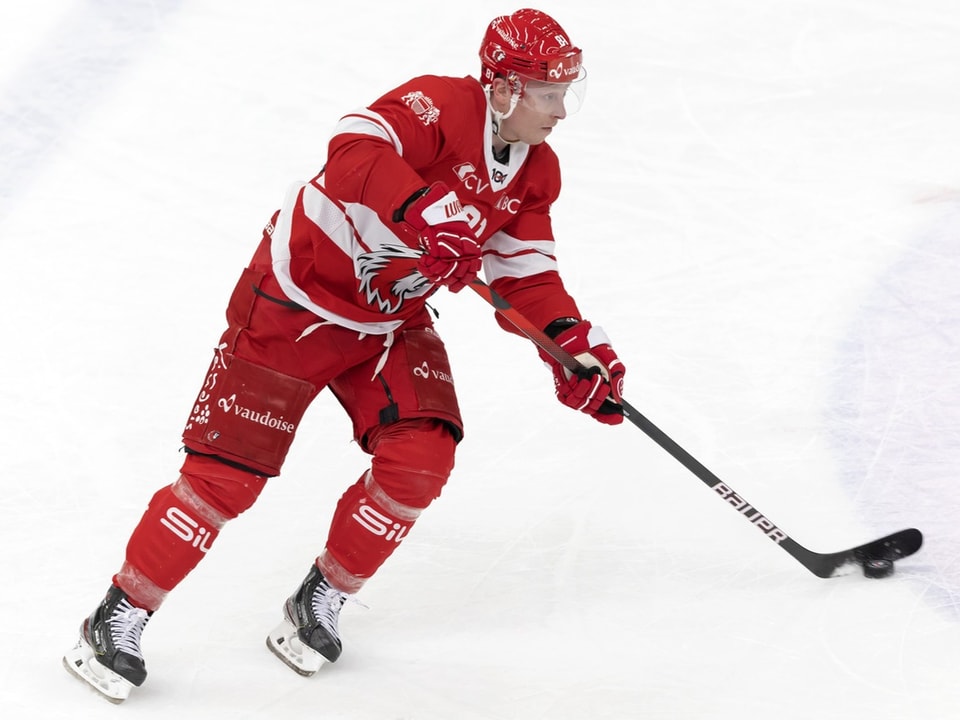 Eishockeyspieler in roter Ausrüstung auf dem Eis.