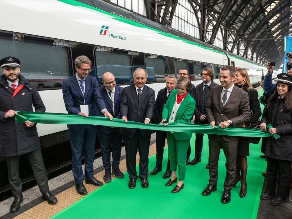 Menschen schneiden grünes Band vor Trenitalia-Zug.