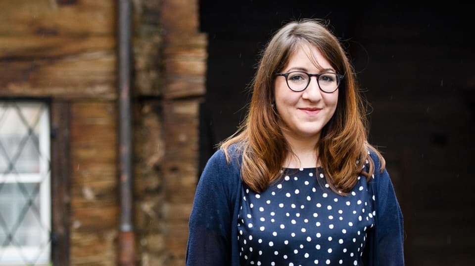 Deborah Feldman vor einem Holzhaus.