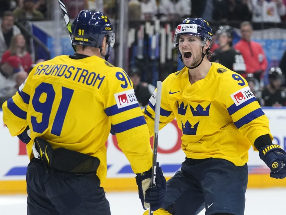 Zwei schwedische Eishockeyspieler in gelben Trikots feiern.