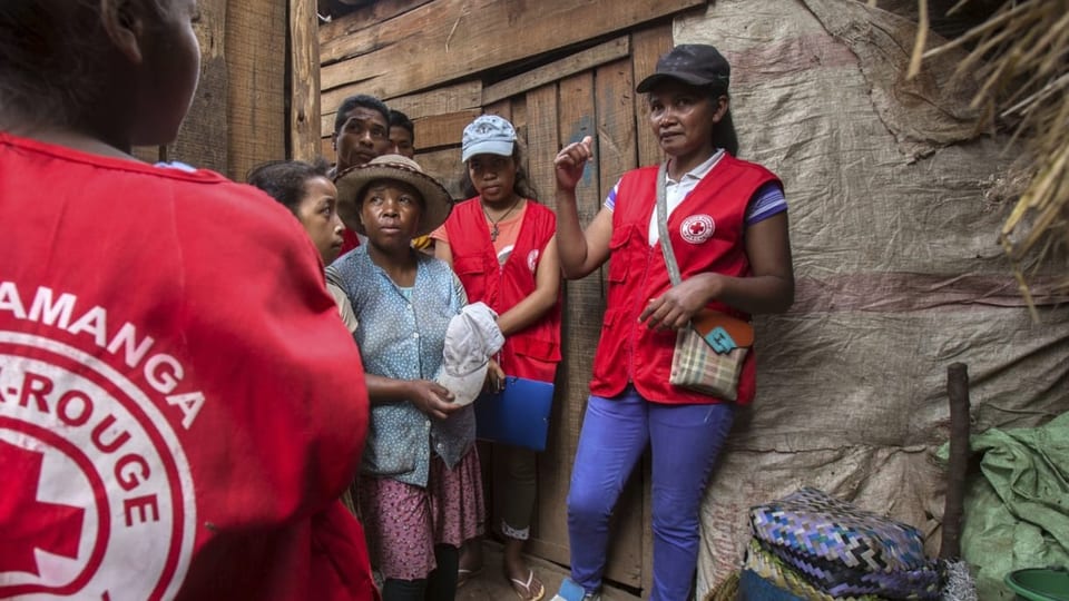 Drei Frauen von einer Hilfsorganisation reden mit Madagassinen.