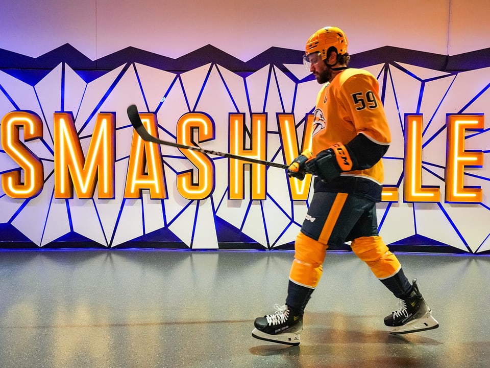 Eishockeyspieler geht an 'SMASHVILLE'-Wand vorbei.