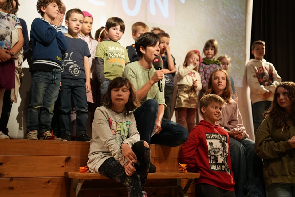 Gruppe von Kindern und Erwachsenen auf einer Bühne.