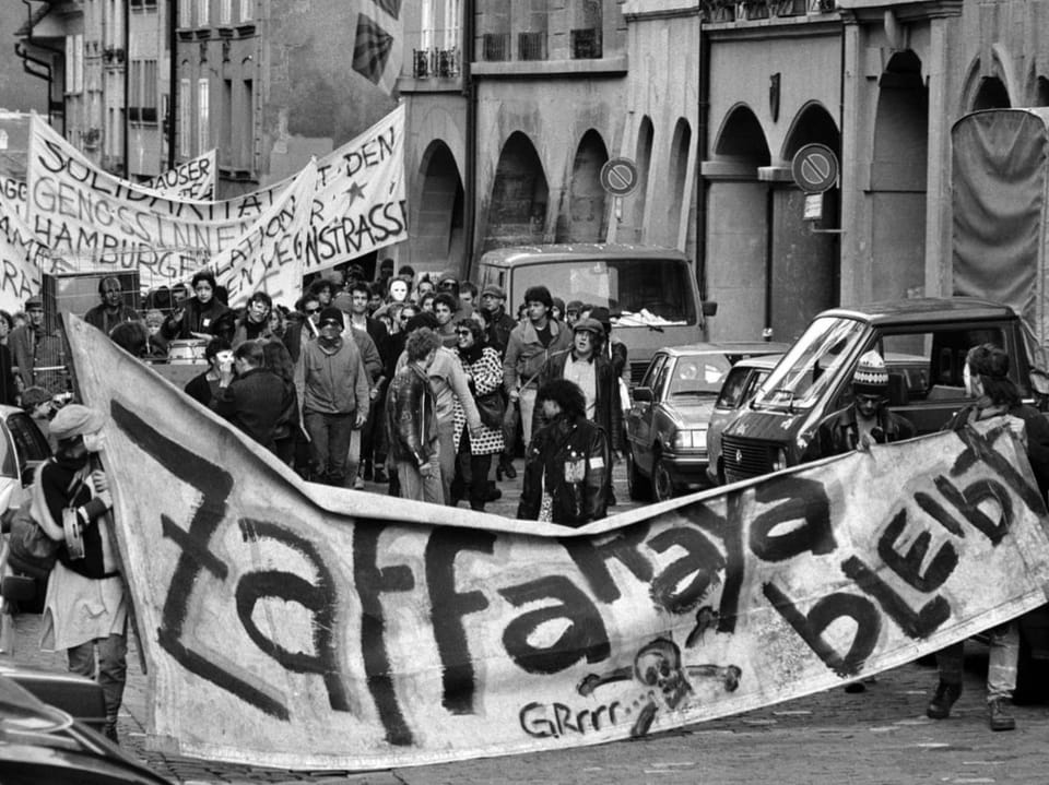 Menschen in der Berner Altstadt mit Transparent «Zaffaraya bleibt»