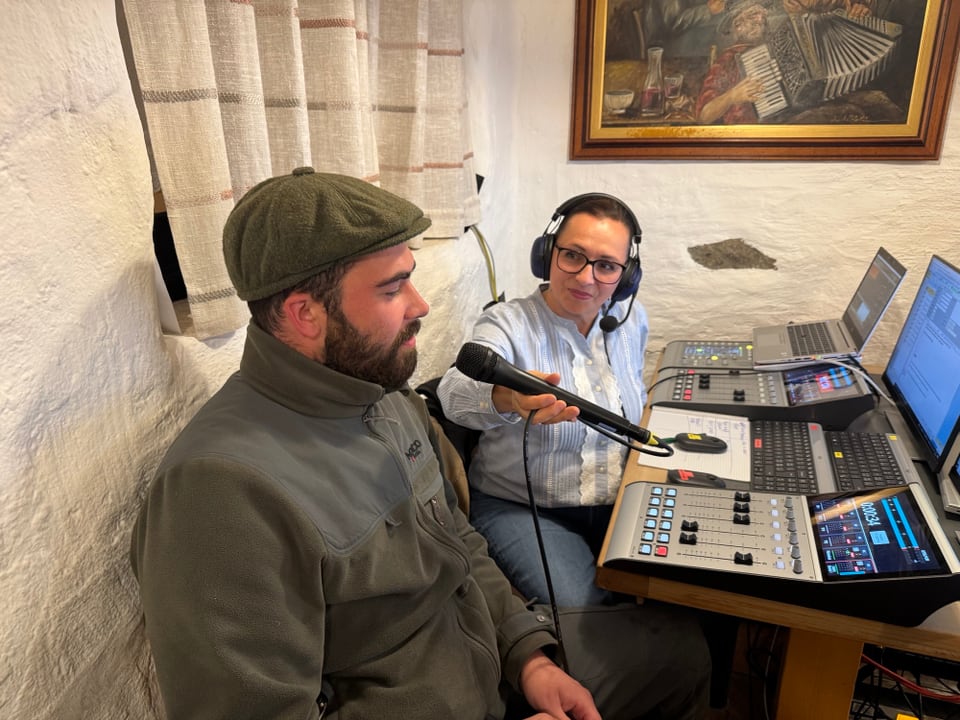 Zwei Männer in Aufnahmestudio, einer spricht ins Mikrofon.