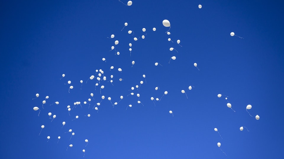 Weisse Ballons steigen in den Himmel.