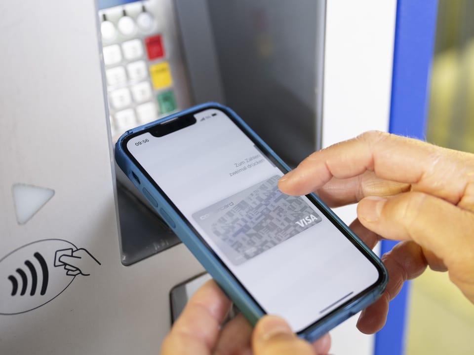 Kontaktloses Bezahlen mit Smartphone an einem Kartenlesegerät.