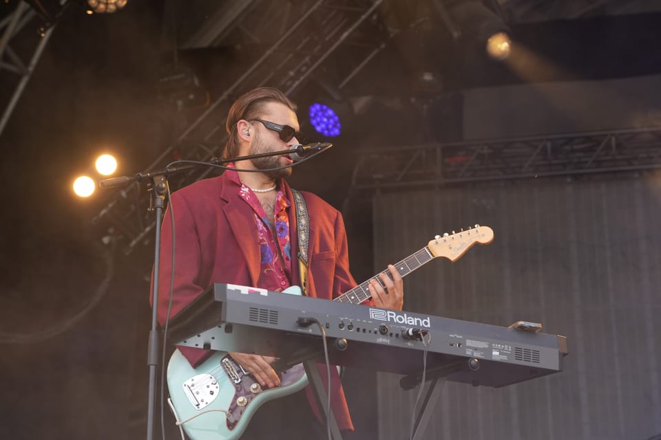 Musiker spielt Gitarre und Keyboard auf einer Bühne am Open Air Lumnezia 2024.