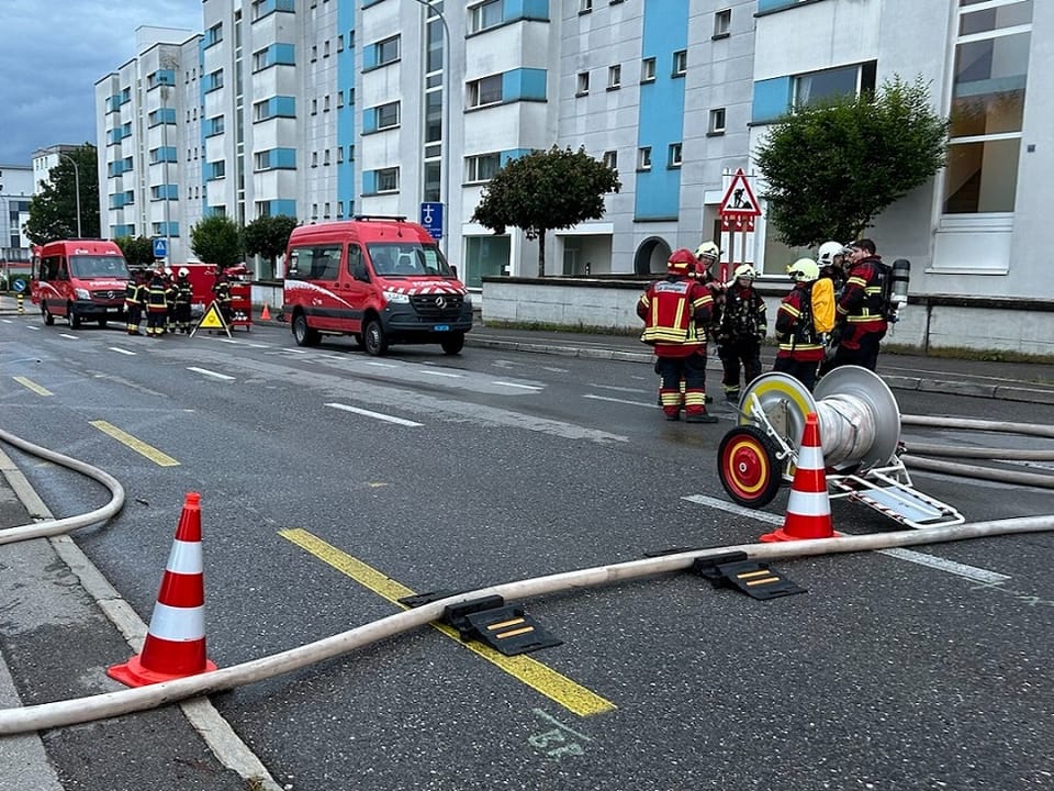Feuerwehrfahrzeuge und -personal in Wohngebietszene.