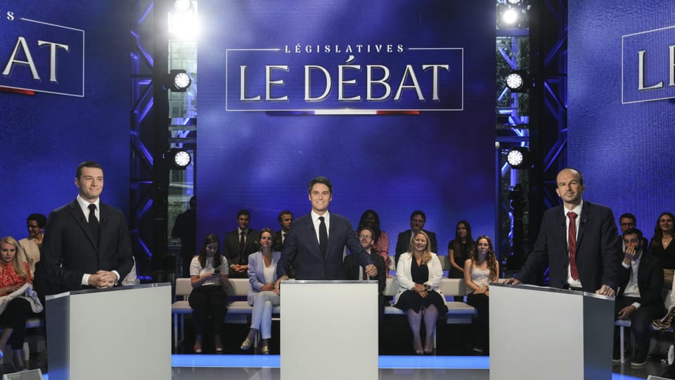 Bardella, Attal und Bompard debattieren auf einer Bühne vor Publikum unter dem Banner «Le Débat».