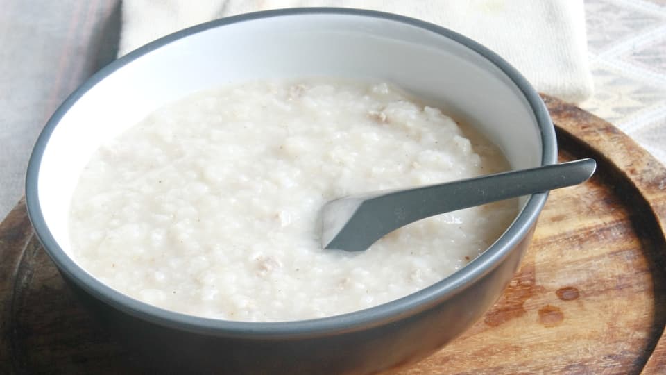 Schüssel Haferschleimsuppe mit Löffel.