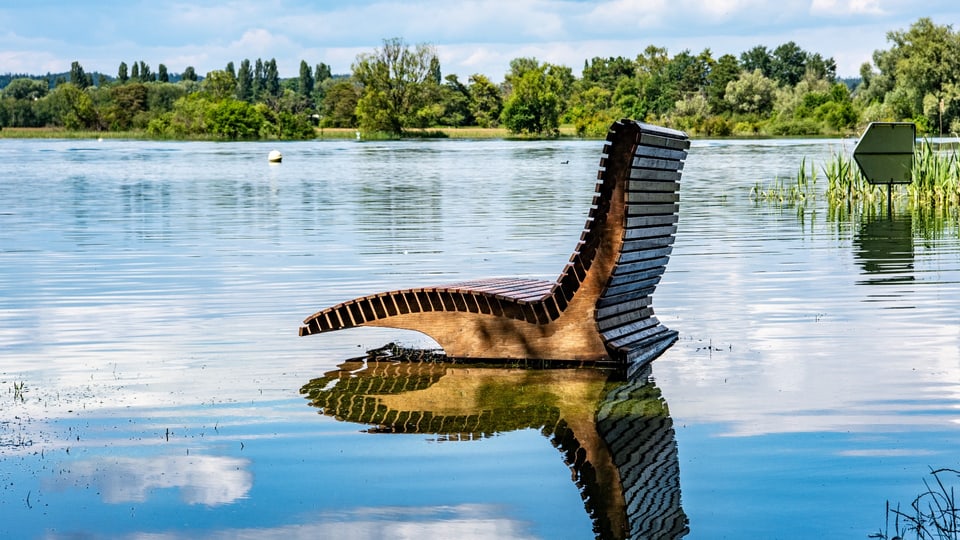 Parkbank steht im Wasser.