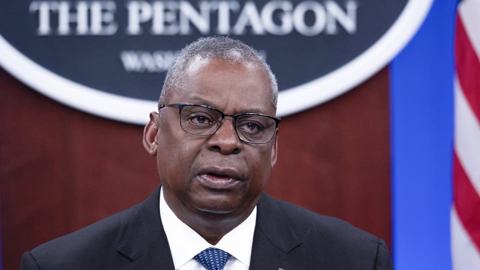 Ein Mann in Anzug und Brille vor einem Schild mit der Aufschrift «The Pentagon»