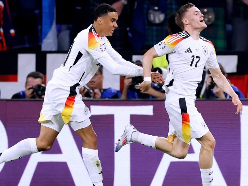 Zwei deutsche Fussballspieler feiern ein Tor während eines Spiels.