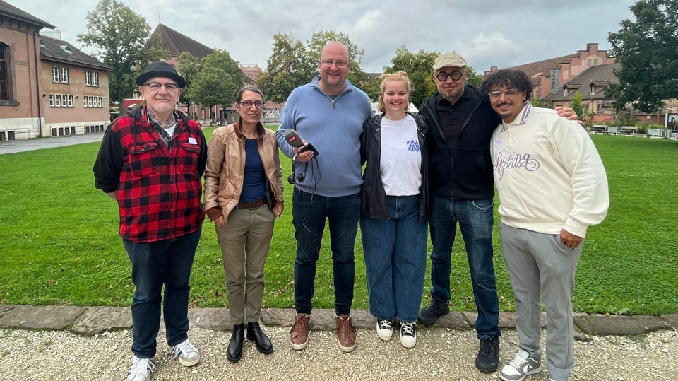 Sechs Menschen auf einer Wiese in Basel.