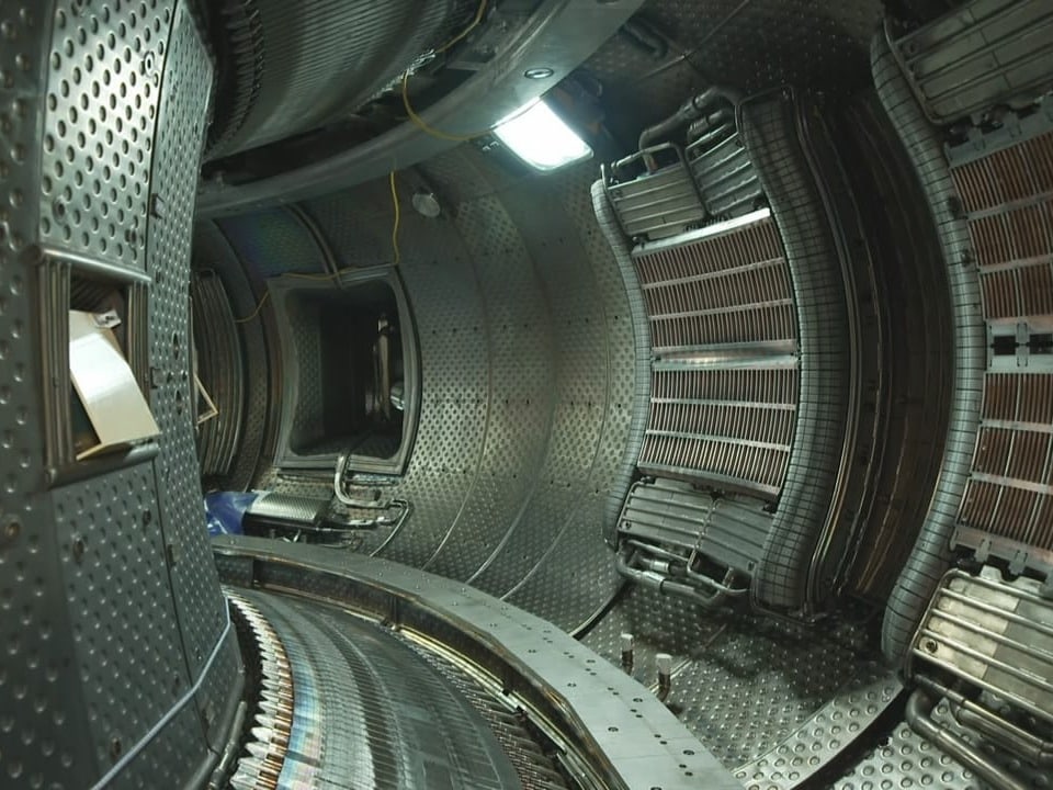 Futuristischer Metalltunnel mit Drähten und Röhren, Teil eines Tokamak-Reaktors.