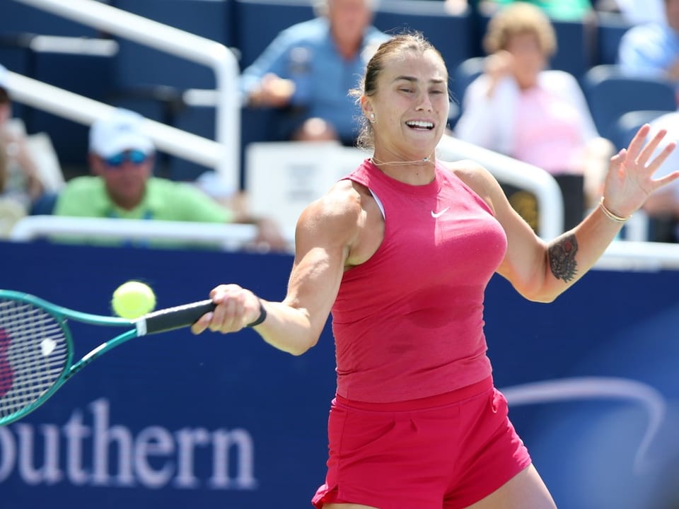 Frau im roten Sportoutfit beim Tennisschlag