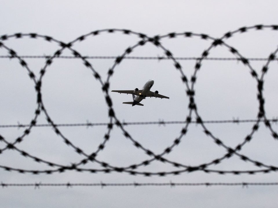 Flugzeug hinter Stacheldraht.