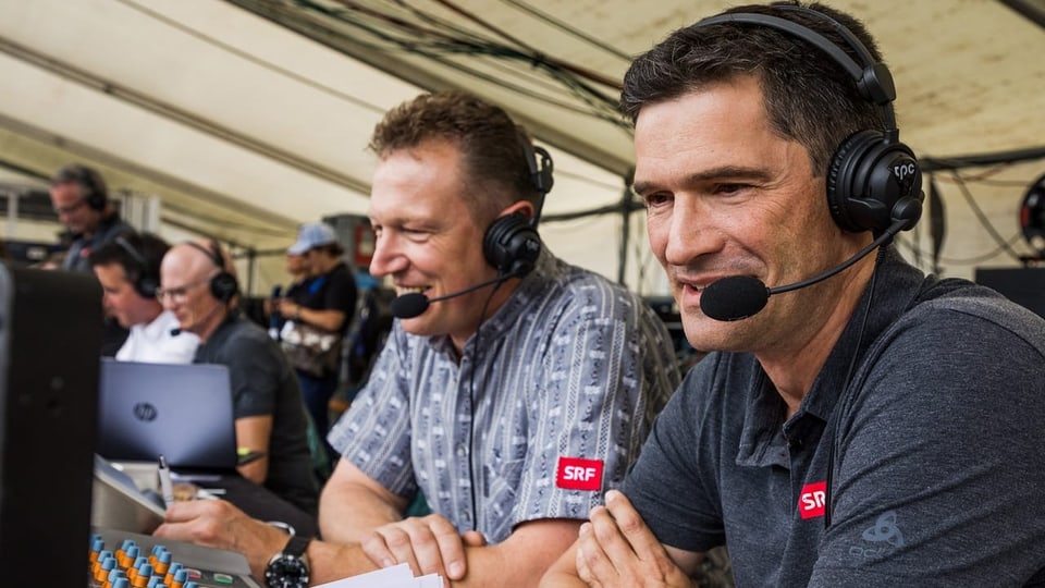 Adrian Käser und Stefan Hofmänner sitzen in der Medienzone. Sie tragen Headsets und blicken auf Bildschirme.